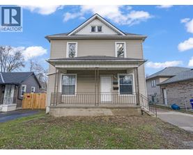 A two-story house with a front porch is for sale.