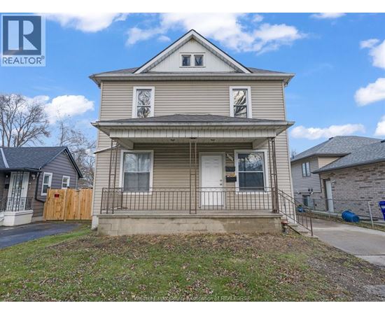 A two-story house with a front porch is for sale.