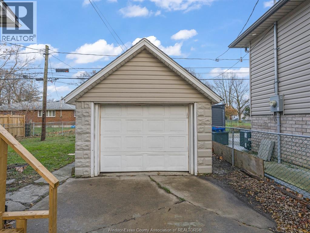 A detached garage with a white door is situated in a residential area.