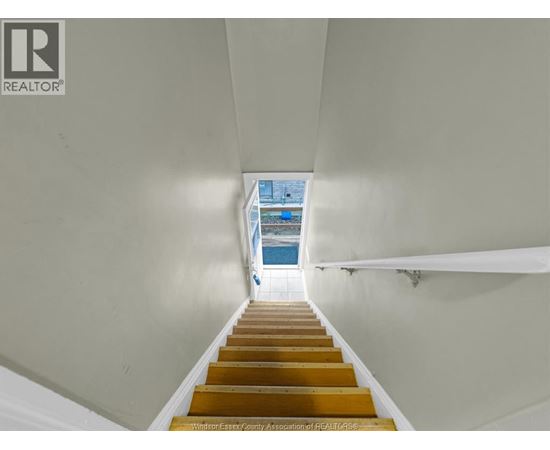 A staircase with wooden steps leading to a blue pool.