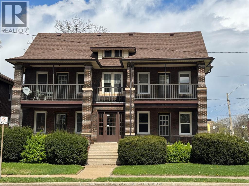 A brick house with a porch and a balcony.