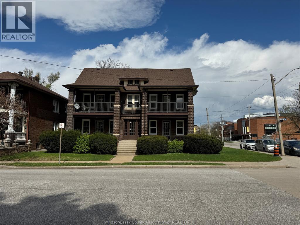 A house with a brown roof and a sign that says REALTOR in front of it.
