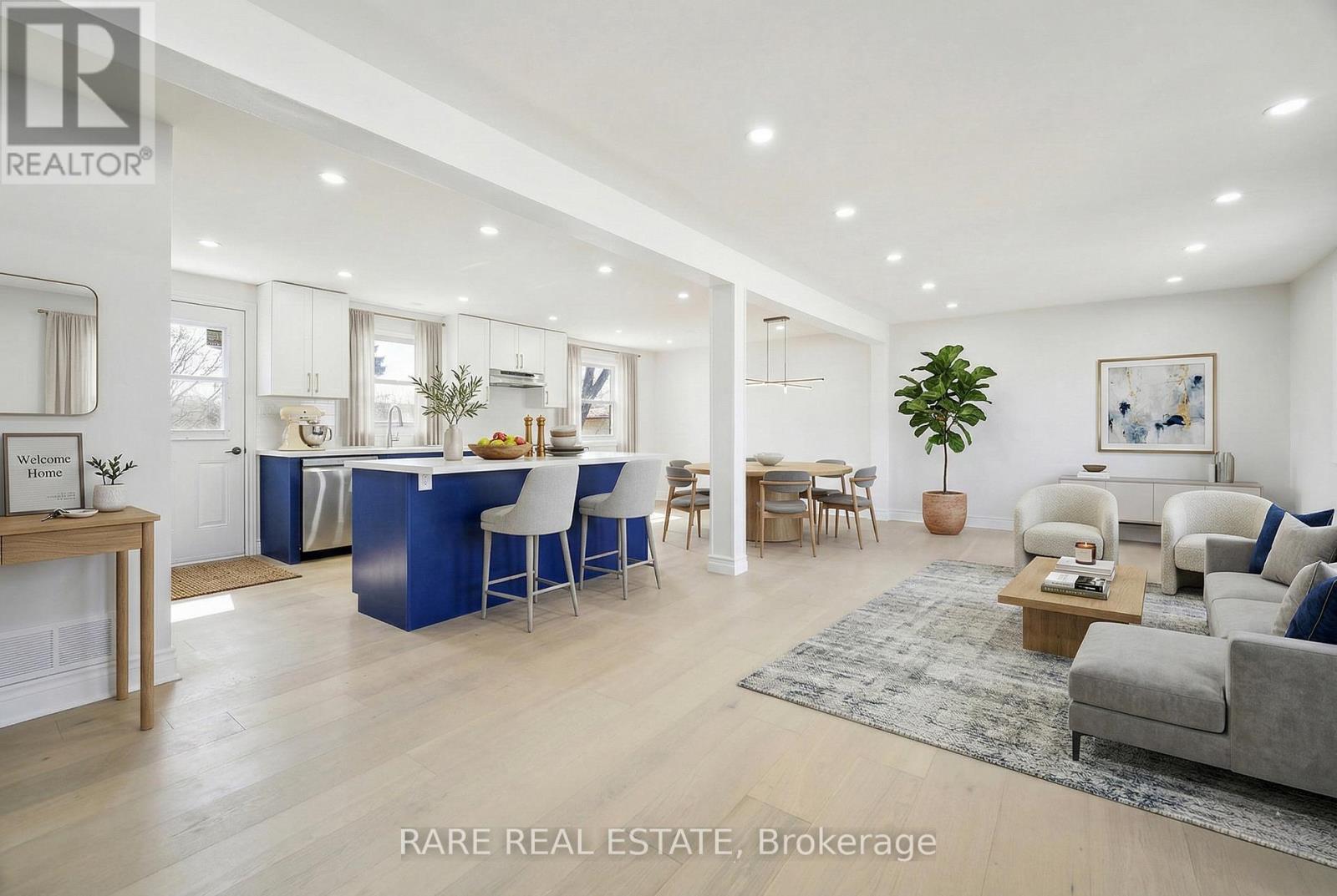 A spacious living room with a dining area and kitchen in the background.