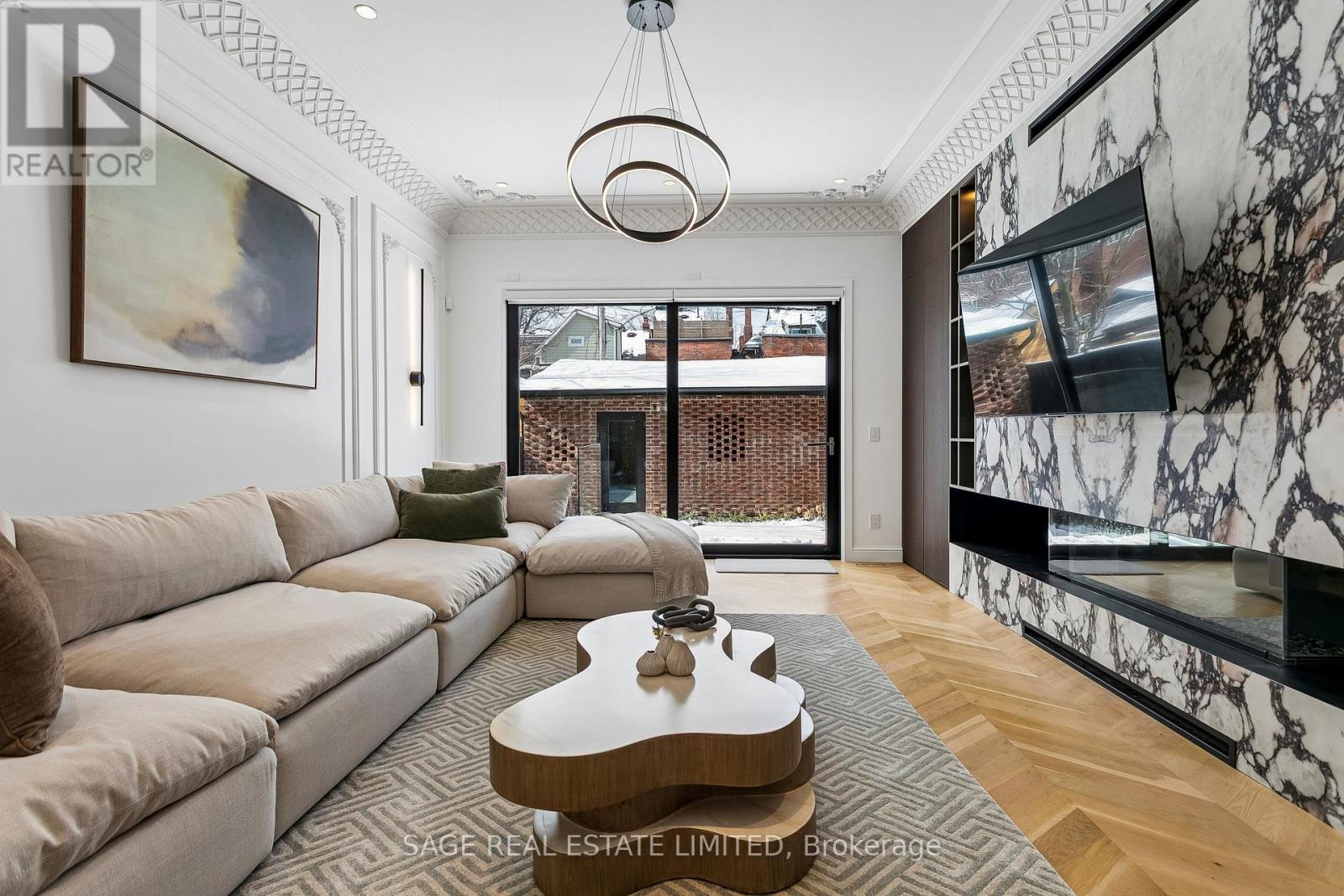 A living room with a beige couch and a coffee table in the center.
