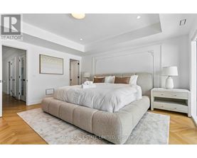 A bedroom with a large bed and a wooden floor.