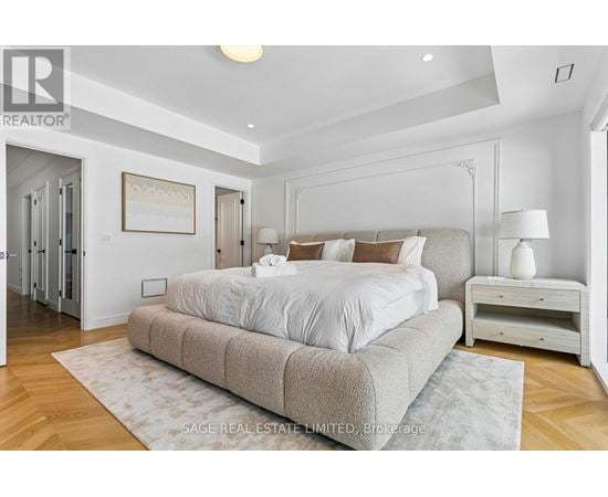 A bedroom with a large bed and a wooden floor.