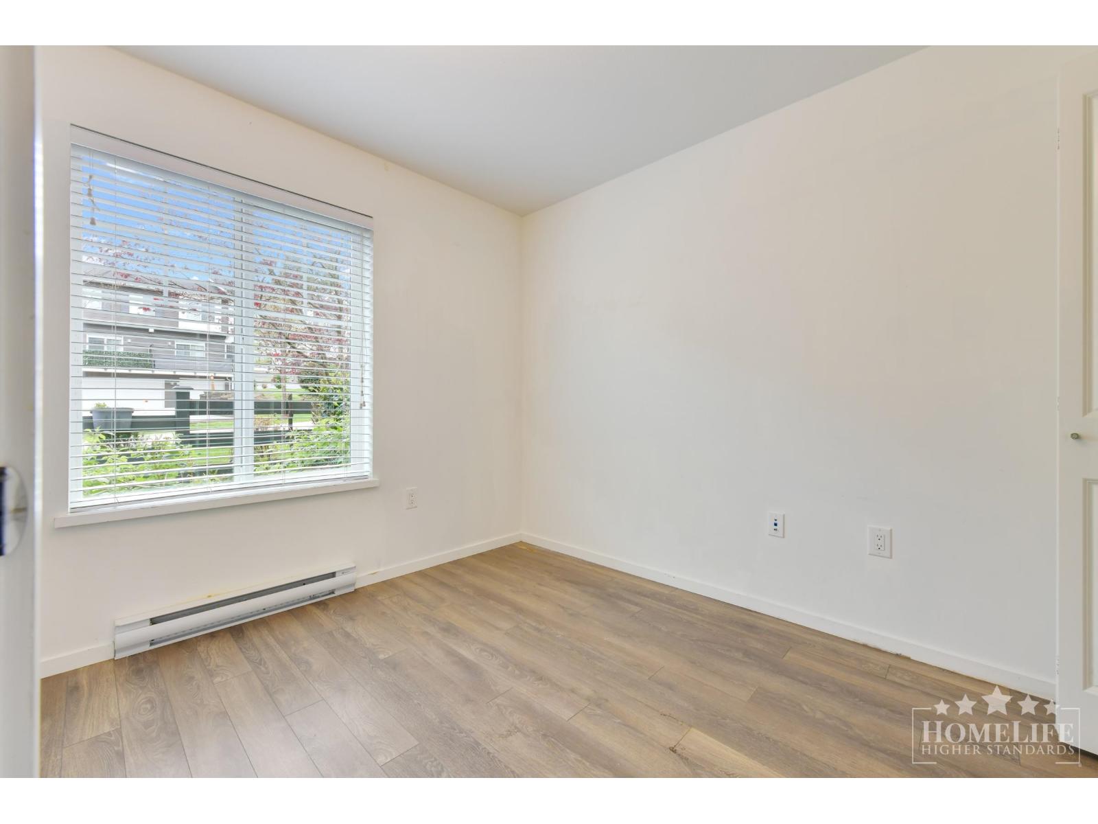 A room with a window and a radiator on the floor.