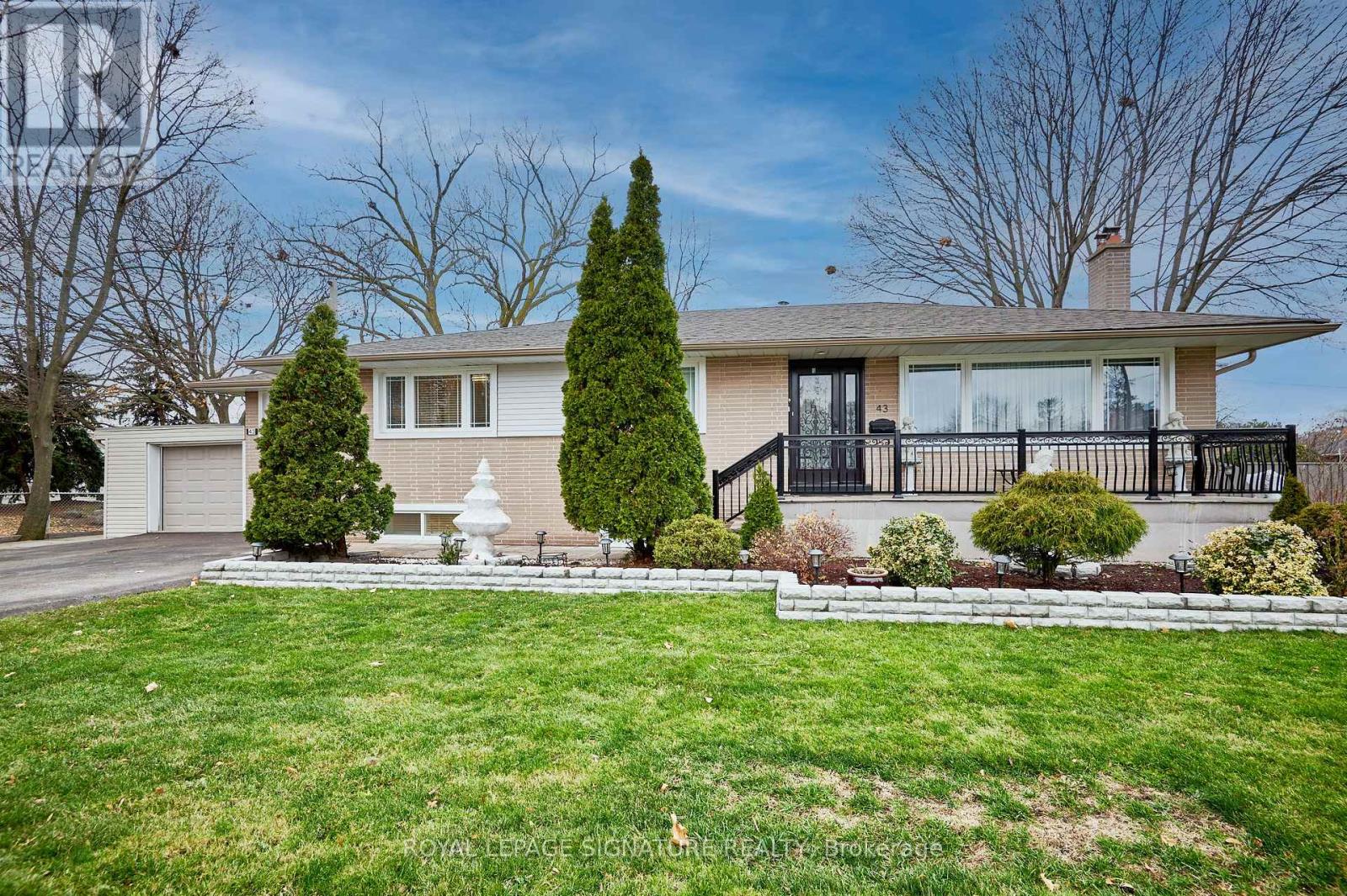 A house with a well-maintained lawn and a white fence.
