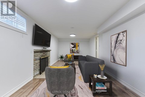 A living room with a grey couch, a coffee table, and a television mounted on the wall.