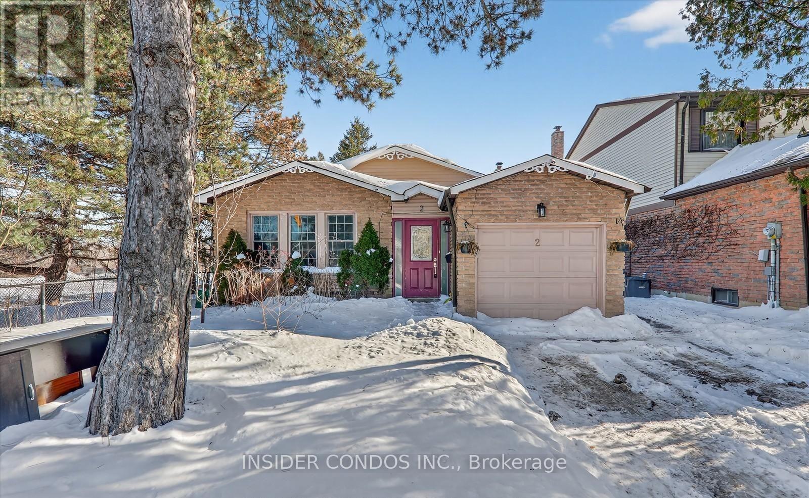 A house with a red door is surrounded by snow.