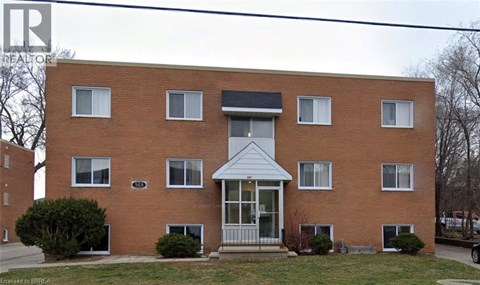A red brick house with a white door and windows.