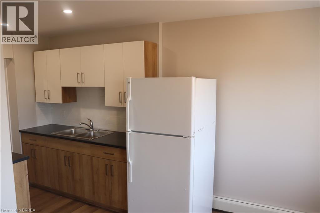 A kitchen with wooden cabinets and a white fridge.
