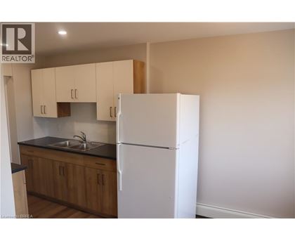 A kitchen with wooden cabinets and a white fridge.