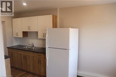 A kitchen with wooden cabinets and a white fridge.