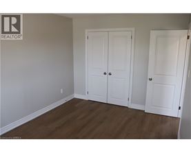 A room with two white doors and a wooden floor.