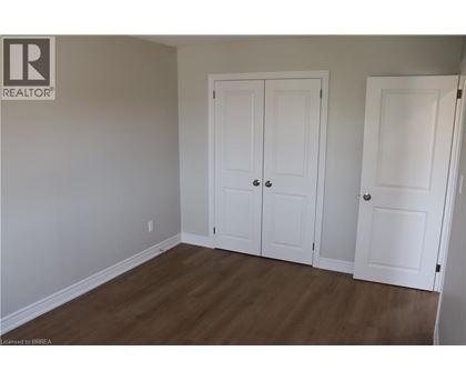 A room with two white doors and a wooden floor.