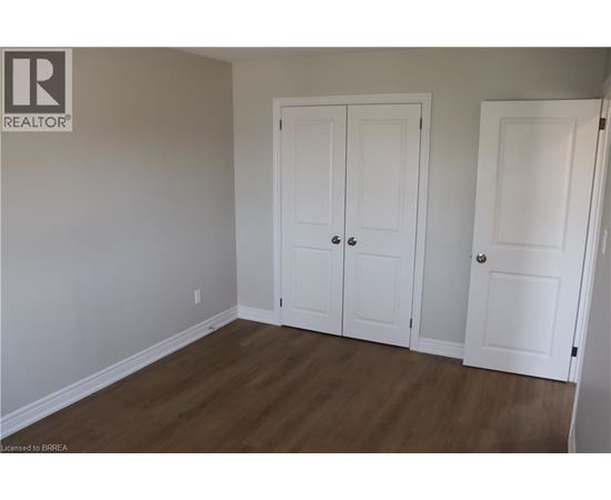 A room with two white doors and a wooden floor.
