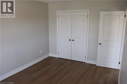 A room with two white doors and a wooden floor.