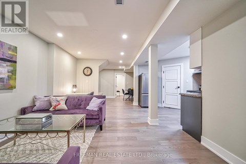 A living room with a purple couch and a glass coffee table.