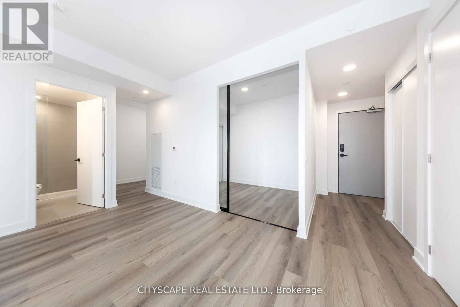 A real estate brokerage image of a spacious room with wooden flooring and white walls.