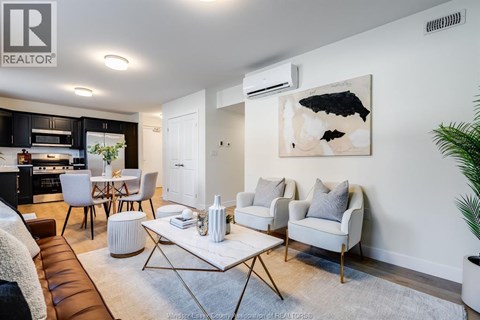 A modern living room with a brown leather couch and a white coffee table.