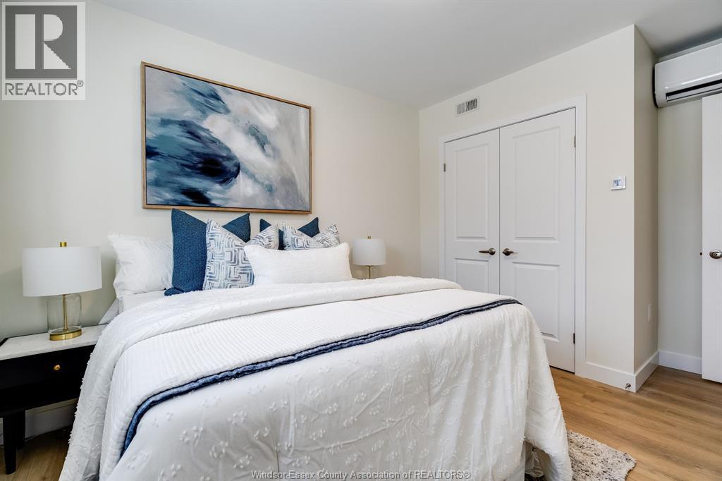 A bedroom with a large bed and a painting on the wall.