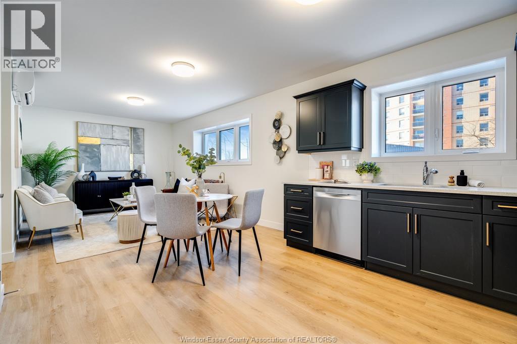A modern kitchen with black cabinets and a dining table with chairs.
