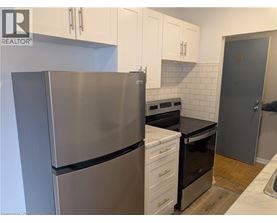 A kitchen with a stainless steel refrigerator and white cabinets.