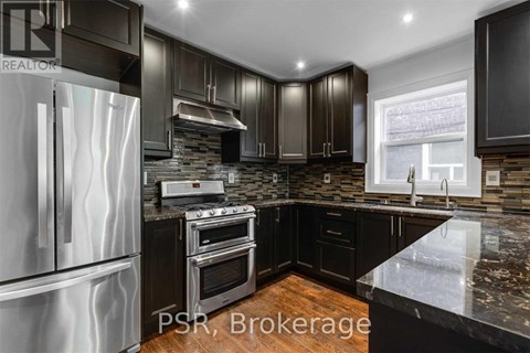 A modern kitchen with dark brown cabinets and a stainless steel refrigerator.