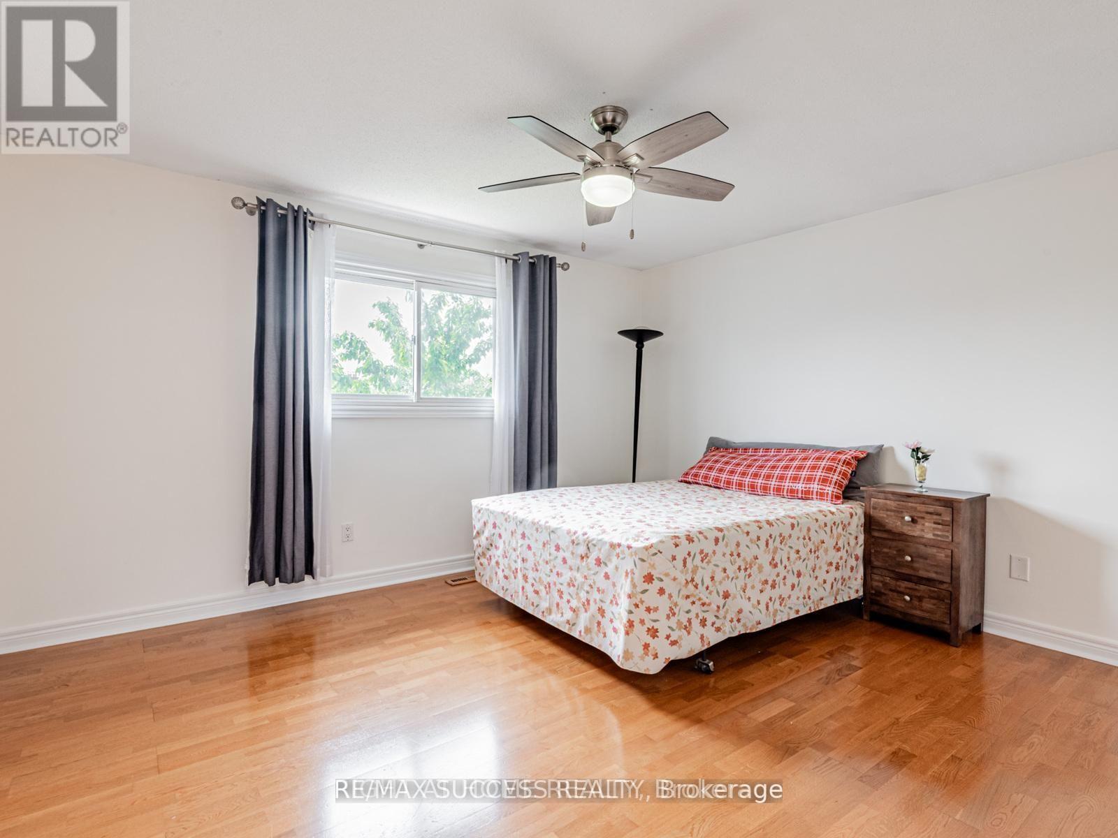 A bedroom with a bed, dresser, and window.