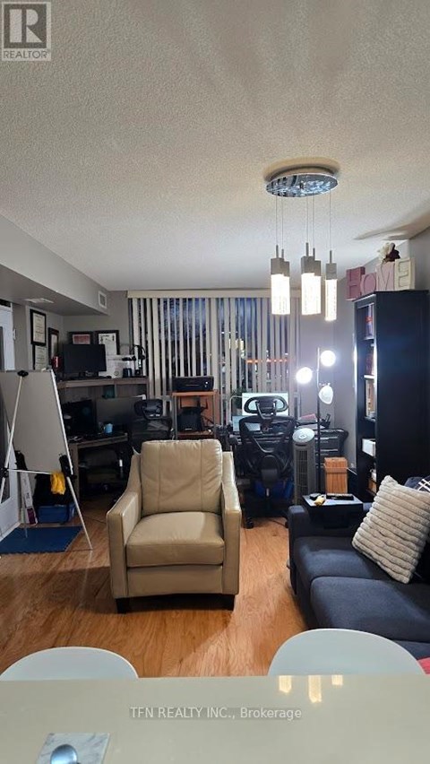 A living room with a brown leather couch and a tan armchair.