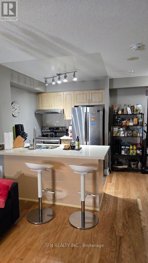 A kitchen with a white countertop and bar stools.