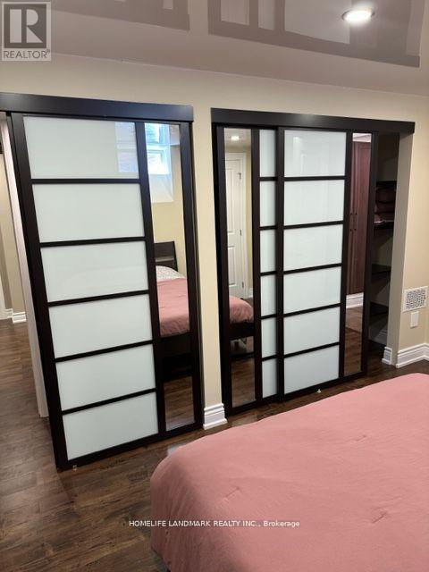 A bedroom with a pink bedspread and a sliding door.