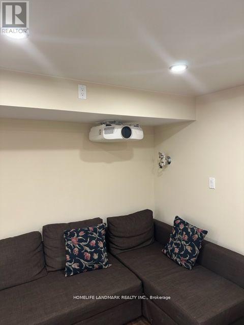 A living room with a couch and a ceiling fan.