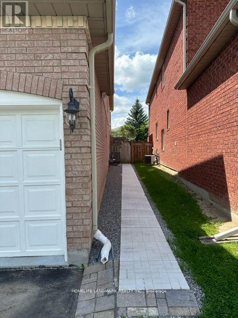 A white garage door is on the left of a brick building.