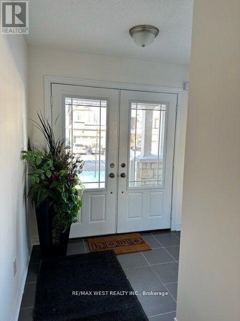 A white door with a glass window is flanked by two windows on either side.