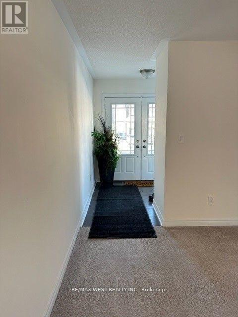 A hallway with a plant on the left and a door on the right.