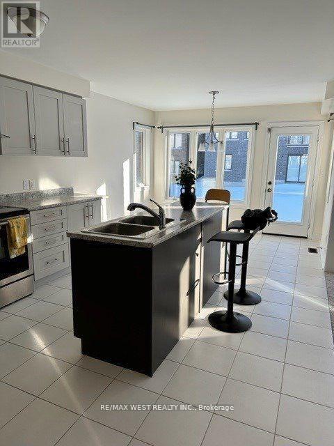 A kitchen with a black island and white cabinets.