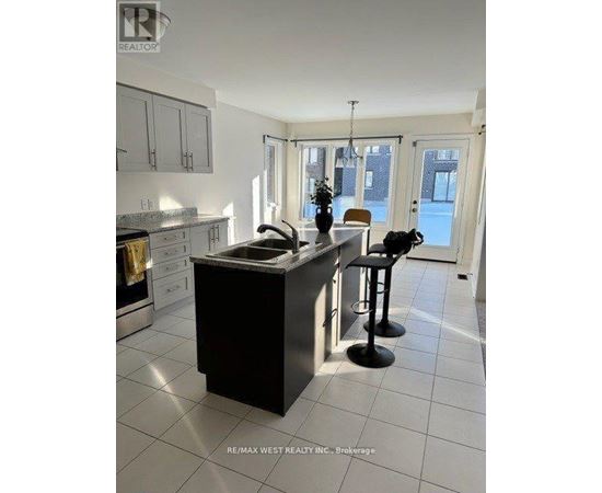A kitchen with a black island and white cabinets.