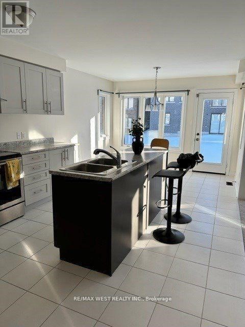 A kitchen with a black island and white cabinets.