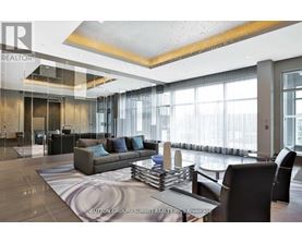 A modern living room with a glass wall and a large window.