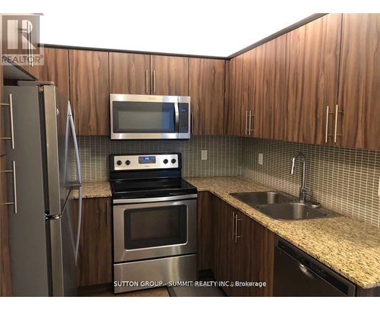 A kitchen with wooden cabinets and stainless steel appliances.