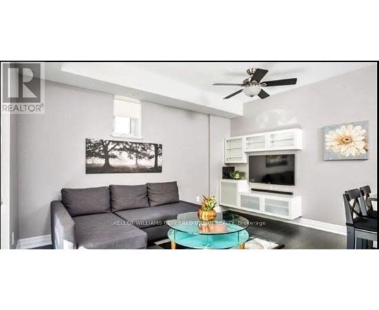 A living room with a grey couch and a black chair.