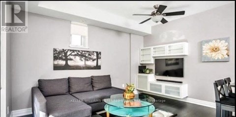 A living room with a grey couch and a black chair.