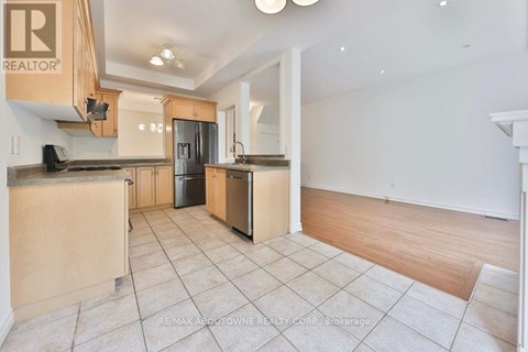 A kitchen with a black refrigerator and wooden cabinets.