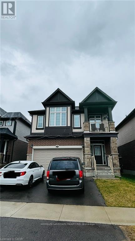 A two-story house with a garage and a car parked in front.