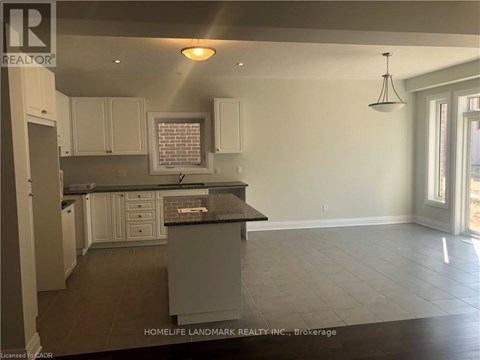 A kitchen with white cabinets and a black countertop.