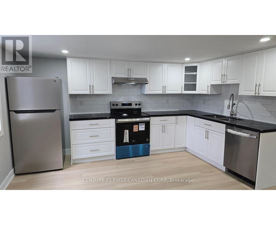 A kitchen with white cabinets and a stainless steel refrigerator.