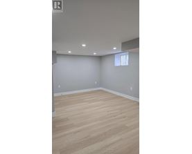 A room with wooden flooring and a window.