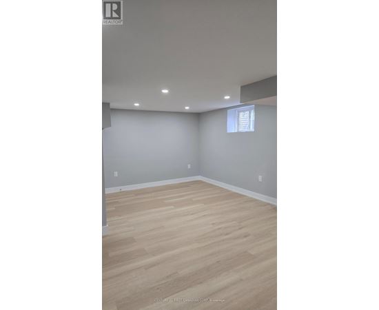 A room with wooden flooring and a window.